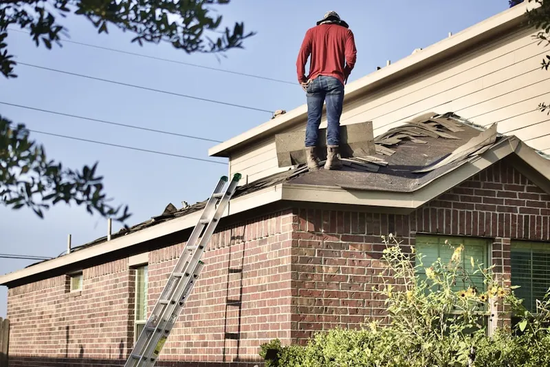 Professional roofer working on a residential roof in Howard